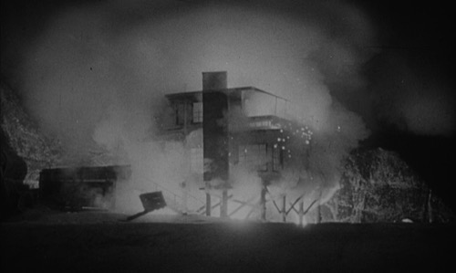 Film still: the ending sequence — the glowing lead-lined valise ("the great whatsit") detonating in the Malibu beach house